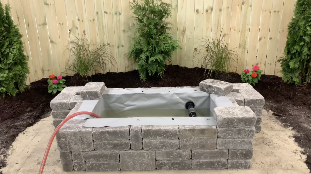 Hardscape Basin being filled up with water from a hose