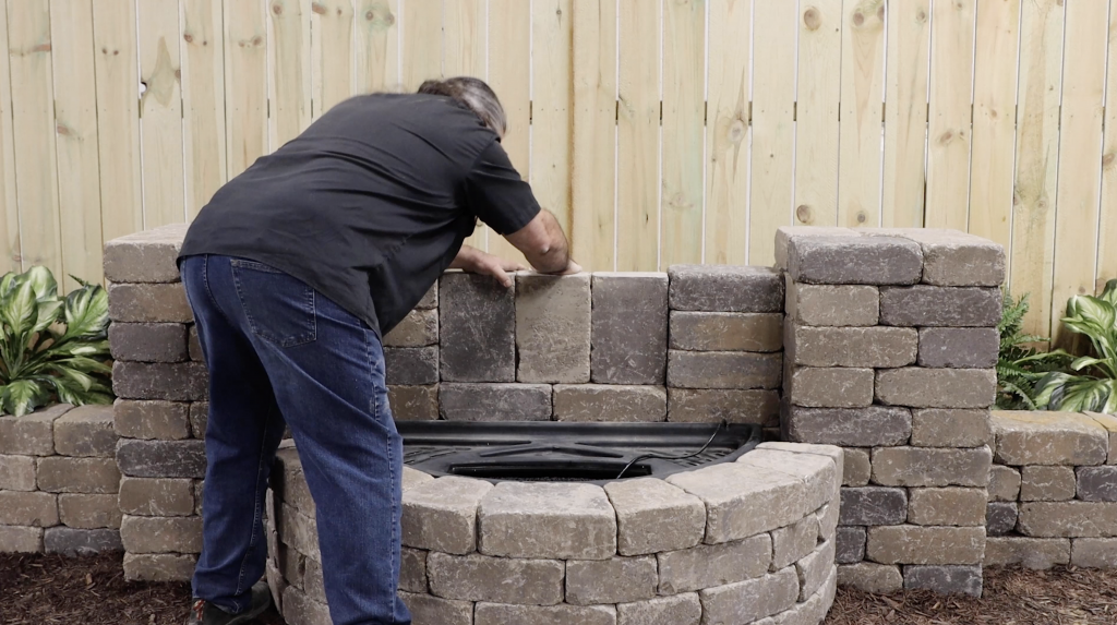 Man placing the hardscape blocks into place for a Colorfalls water feature